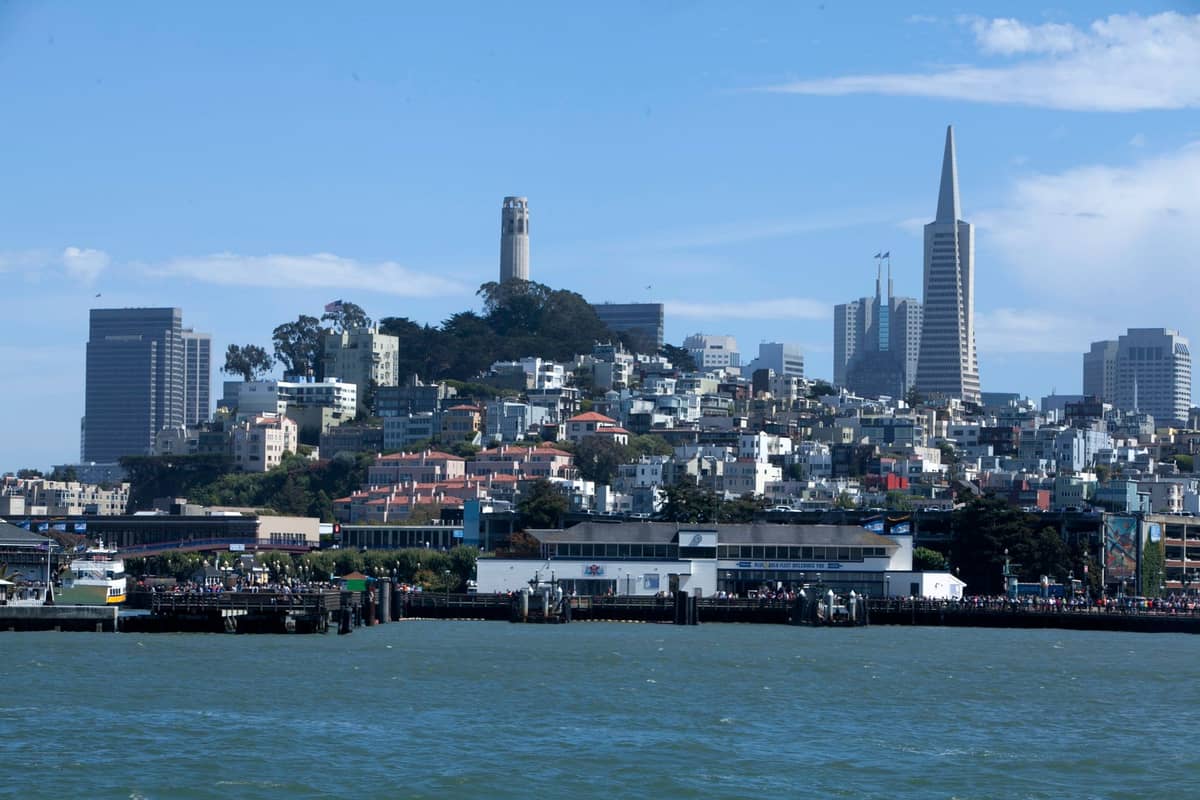 San Francisco Skyline von der Bucht aus, mit dem Coit Tower, der Transamerica Pyramid und einer Vielzahl von Wohn- und Geschäftsgebäuden an einem klaren Tag.