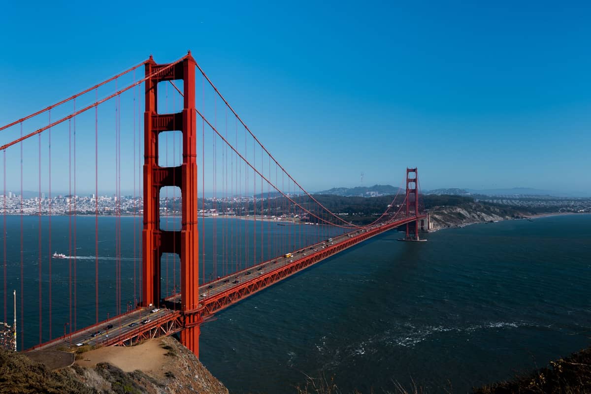 Die Golden Gate Bridge überspannt die San Francisco Bay an einem klaren Tag, aufgenommen von einem Aussichtspunkt in den Marin Headlands mit der Skyline der Stadt im Hintergrund.
