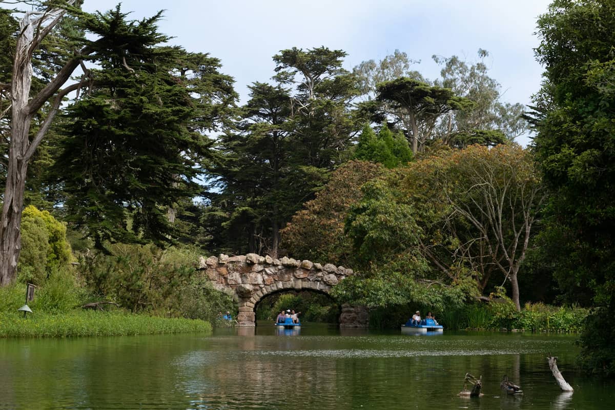 Pedalinhos no Stow Lake com ponte de pedra e árvores no Golden Gate Park, São Francisco