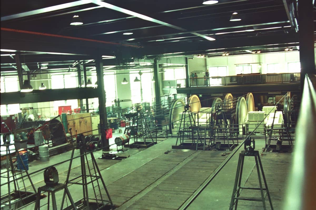 Innenansicht des San Francisco Cable Car Museum mit großen funktionierenden Seilrädern, Maschinen und Laufstegen in einem geräumigen Raum im Industriestil.