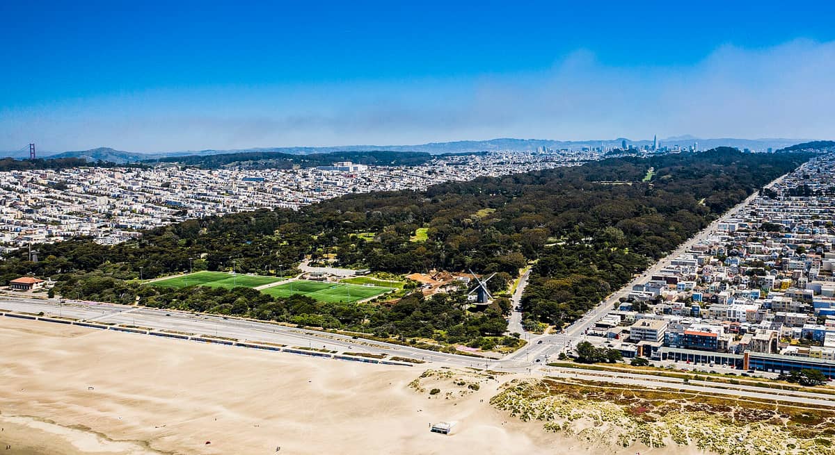 Luftaufnahme der westlichen Stadtteile von San Francisco mit dem Golden Gate Park, Ocean Beach und Reihen von Wohnhäusern, die sich zur Skyline der Stadt erstrecken.