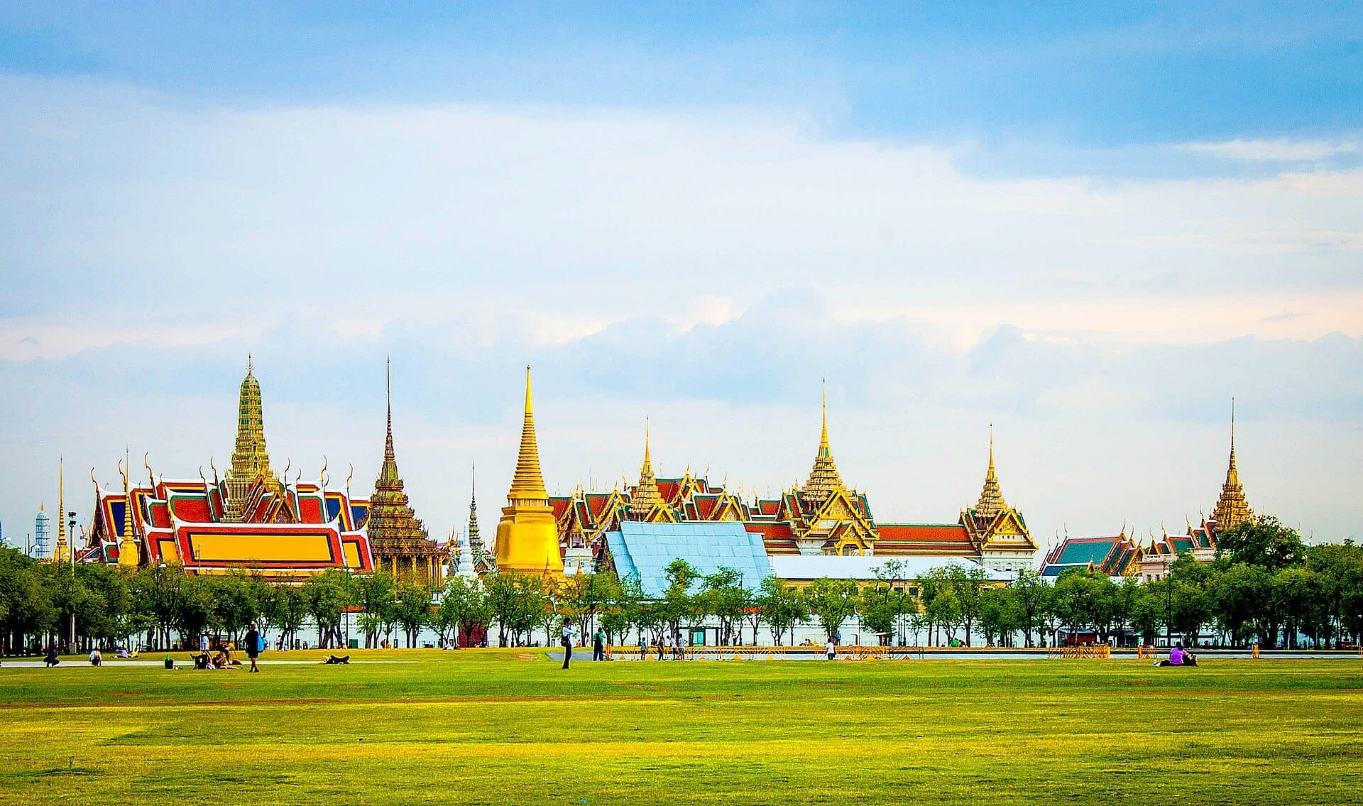 Il campo aperto di Sanam Luang a Bangkok con il Grand Palace e le guglie dei templi sullo sfondo