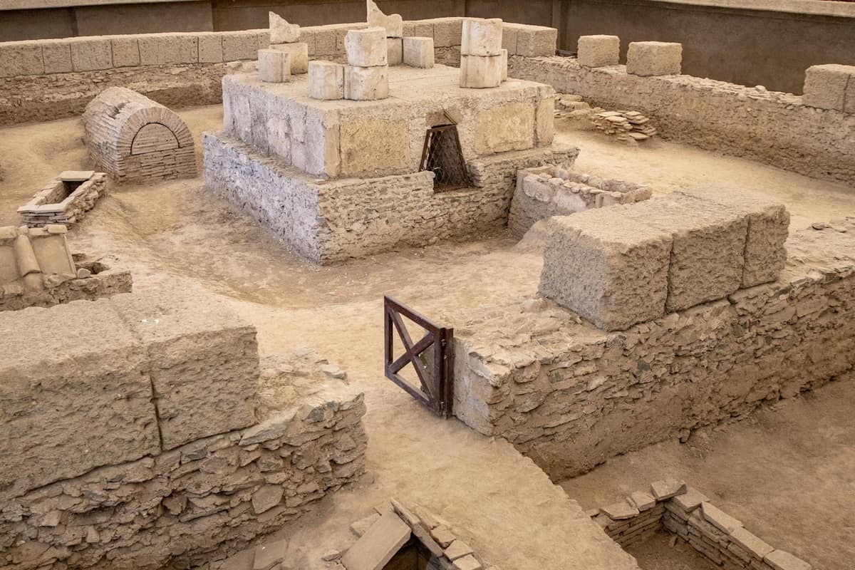 Steinruinen aus der Bronzezeit an der archäologischen Stätte Akrotiri auf Santorini, mit erhaltenen Mauern und Strukturen unter einem Schutzdach.