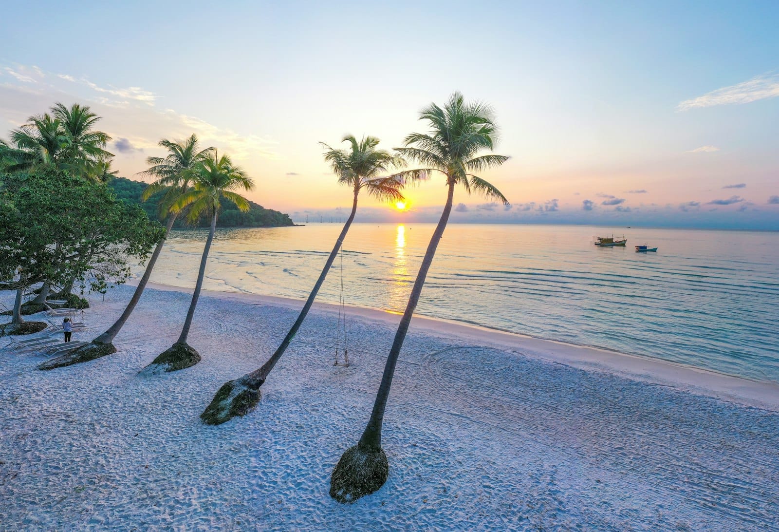 Sao Beach a Phu Quoc al tramonto con palme inclinate, sabbia bianca e mare turchese calmo