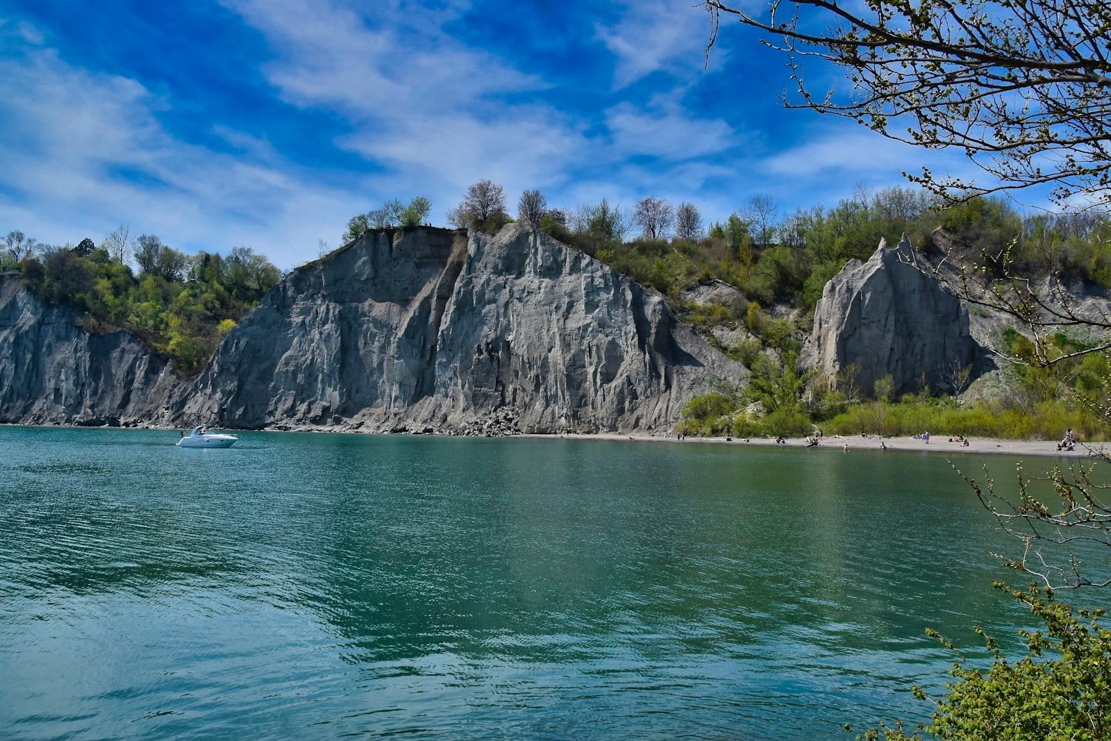 วิวทิวทัศน์หน้าผา Scarborough Bluffs เหนือน้ำสีฟ้าสดของทะเลสาบ Ontario ใต้ท้องฟ้าสีฟ้ามีเมฆกระจาย