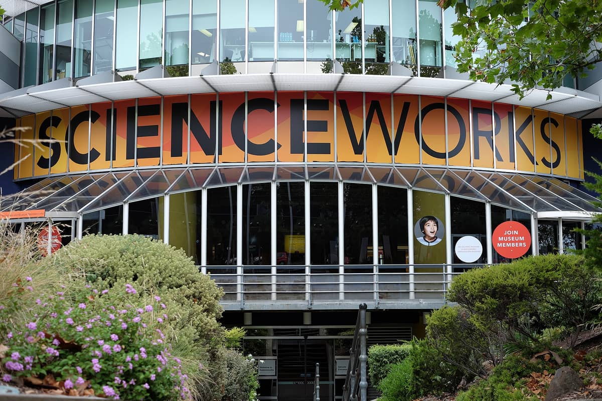 Außenansicht des Haupteingangs von Scienceworks Melbourne mit dem großen SCIENCEWORKS-Schriftzug über den Glastüren und Pflanzen davor.