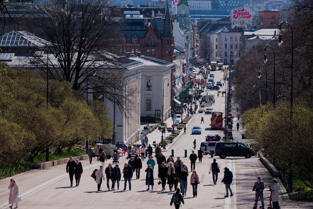 ทัศนียภาพถนน Karl Johans gate ในใจกลางออสโล เต็มไปด้วยผู้คน อาคารประวัติศาสตร์ และป้ายไฟ Freia ที่เห็นได้ไกล