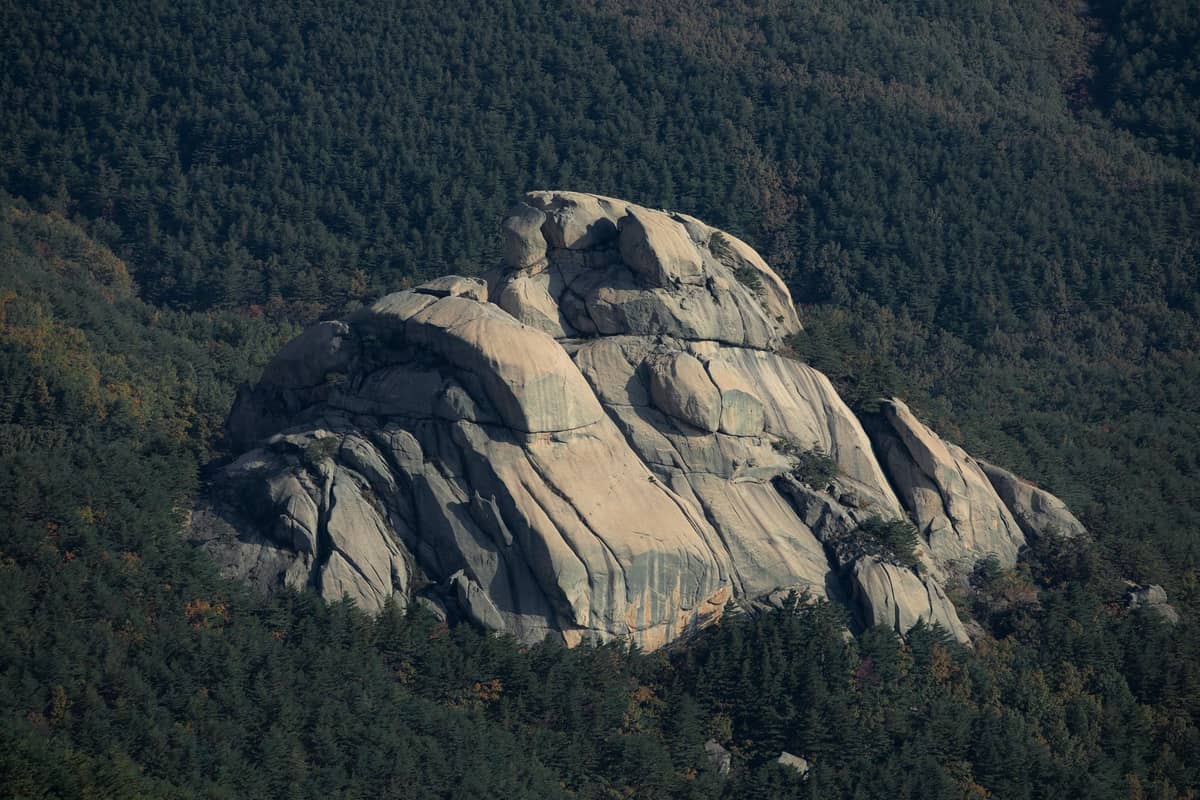 Pico de granito cercado por florestas no Parque Nacional Bukhansan, um popular destino de caminhada na primavera perto de Seul.