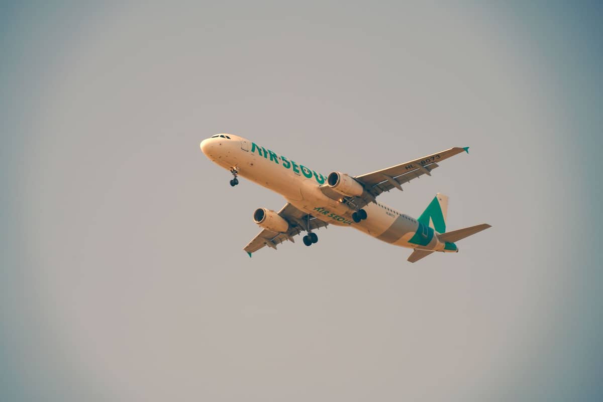 Avião da Air Seoul voando no céu, visto de baixo, trem de pouso abaixado, fundo de céu limpo