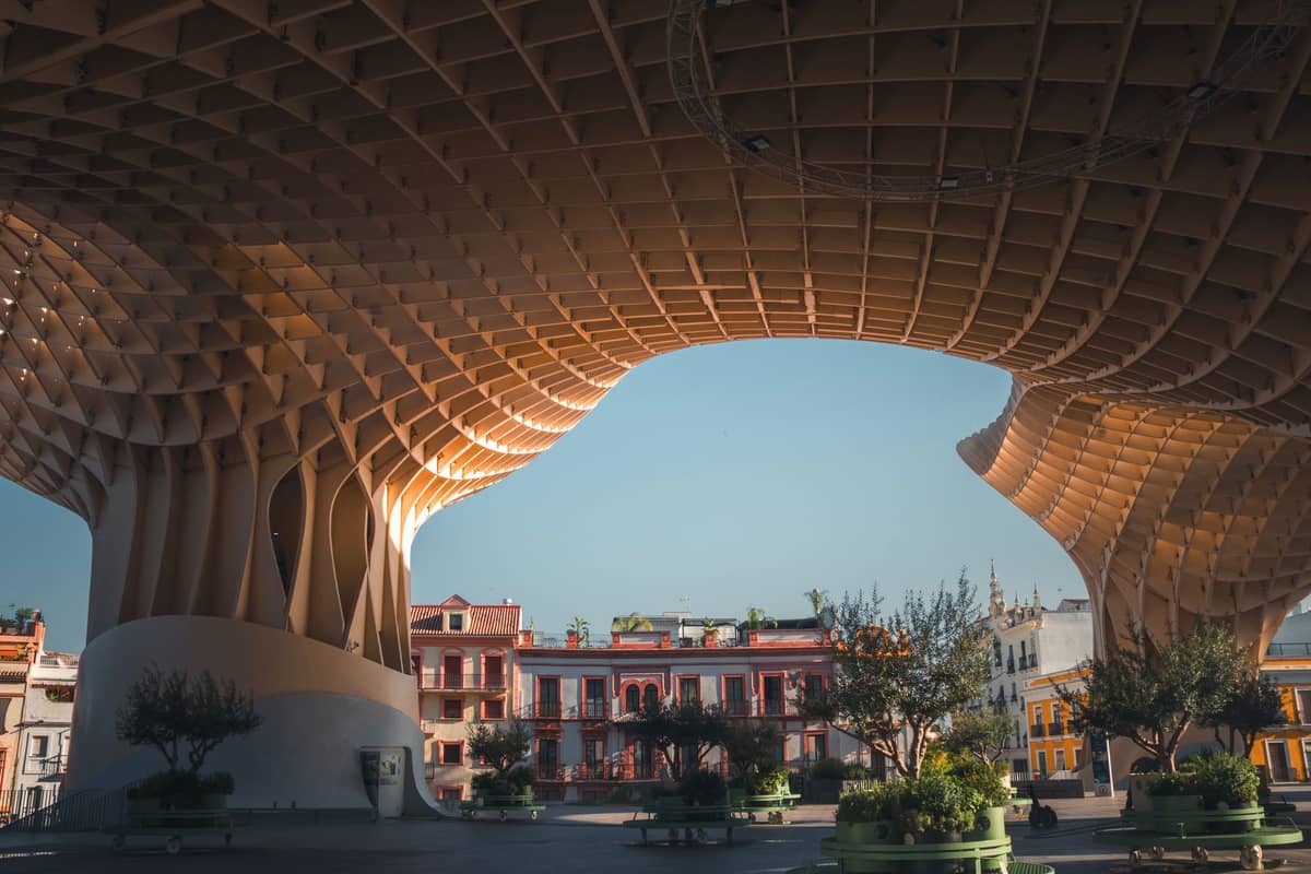 มุมกว้างใต้ Metropol Parasol ที่เซบียา เห็นหลังคาไม้โค้งเหนือ Plaza de la Encarnación รายล้อมด้วยตึกสีสันสดใส