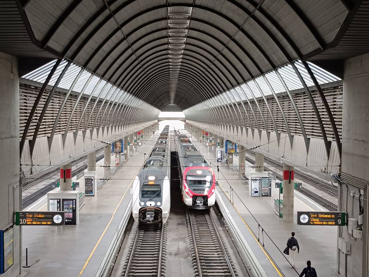 ภาพมุมกว้างของชานชาลารถไฟโมเดิร์นที่สถานีในสเปน พร้อมรถไฟ AVE ความเร็วสูง สื่อถึงการเดินทางระหว่างเซบีย่าและคอร์โดบา