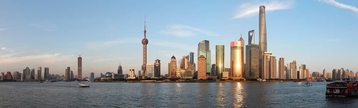Panoramablick auf die Skyline von Lujiazui in Shanghai mit den drei ikonischen Wolkenkratzern: Shanghai Tower, Jin Mao Tower und dem Shanghai World Financial Center.
