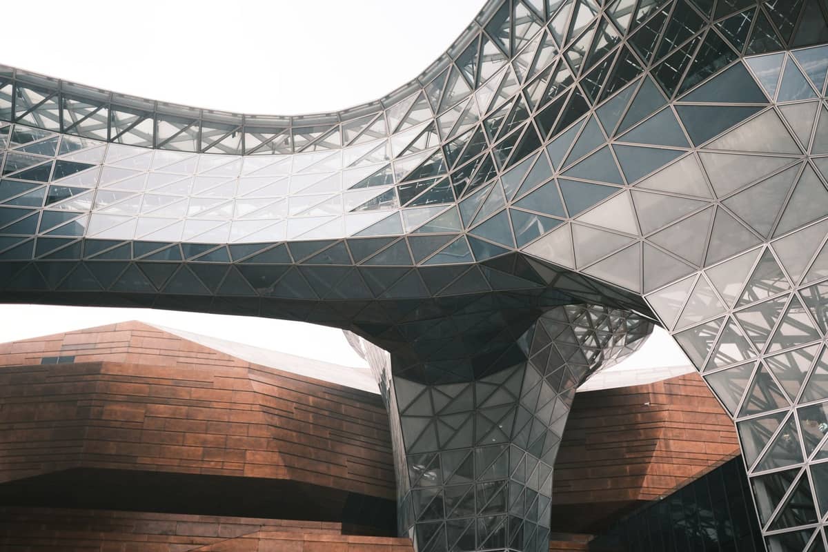 Vue spectaculaire d'un musée moderne en verre et acier aux formes géométriques, accents en bois et structures courbes à Shanghai.