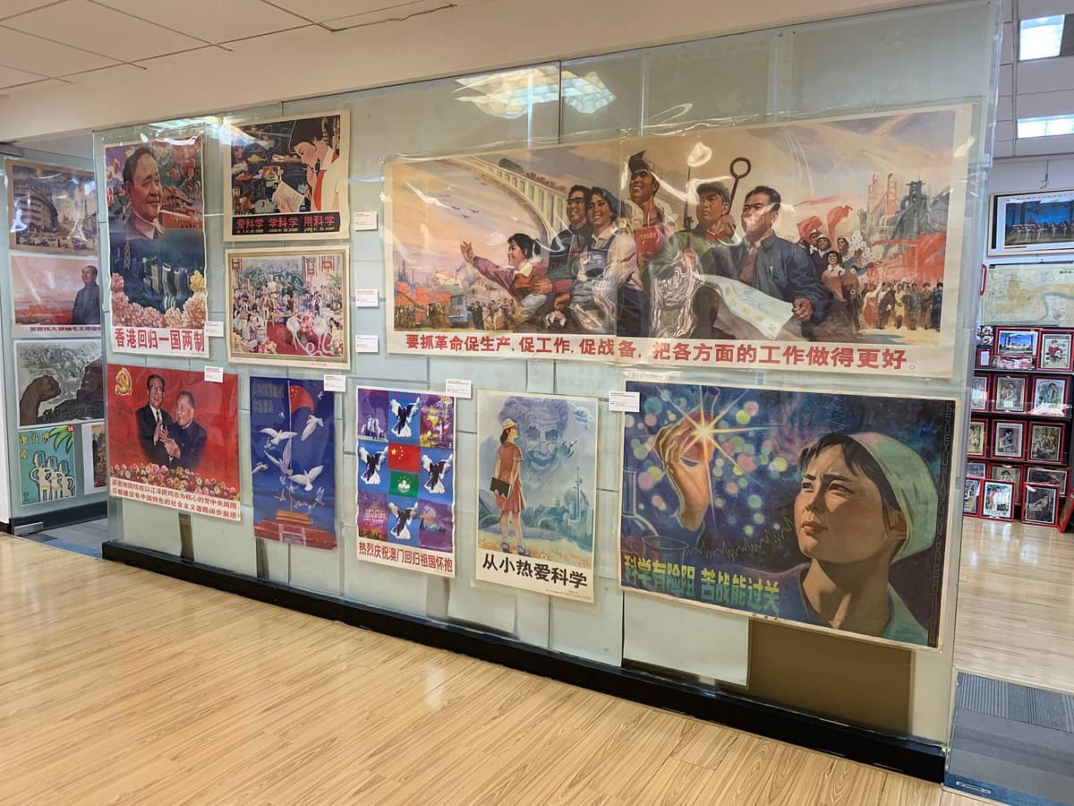 Ausstellungswand im Shanghai Propaganda Poster Art Centre mit originalen chinesischen Propagandaplakaten des 20. Jahrhunderts hinter Glas.