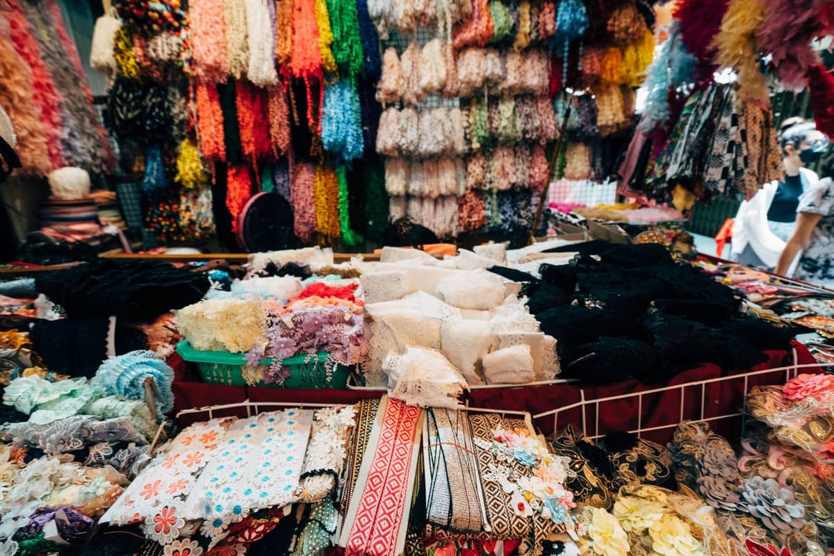 Fabric market stall in Shanghai bustling with colorful ribbons, laces, and textiles stacked on shelves and tables