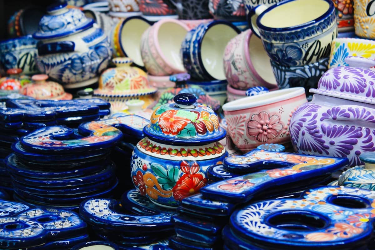 Bunte handbemalte Talavera-Keramik, darunter Krüge und Teller, auf einem mexikanischen Kunsthandwerksmarkt in Guadalajara.
