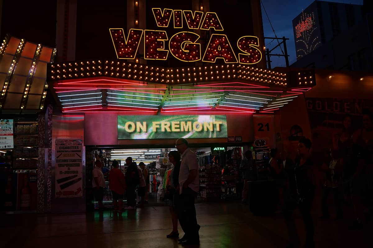 ร้านของที่ระลึก Viva Vegas พร้อมไฟนีออนบน Fremont Street มีนักเดินถนนเดินผ่านและจัดแสดงสินค้าสำหรับนักท่องเที่ยวภายในร้าน