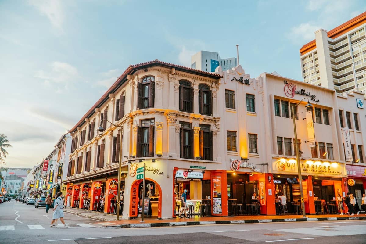 Vibrant street in Singapore at dusk lined with historic shophouses and lit-up restaurant fronts, illustrating a neighbourhood known for diverse dining options.