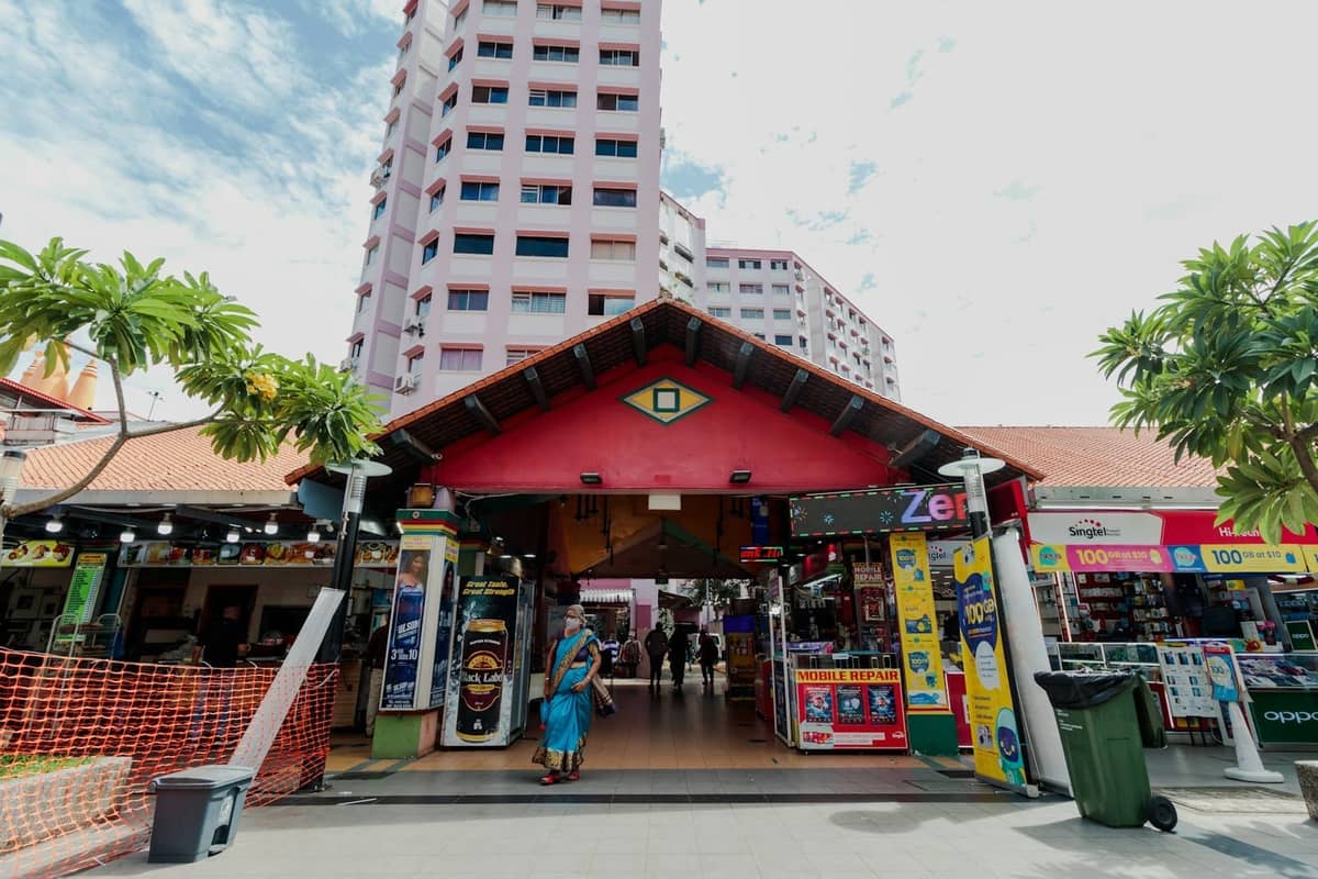 Colorful entrance to an electronics shopping center in Singapore, with shopfronts selling gadgets and accessories and people walking inside.