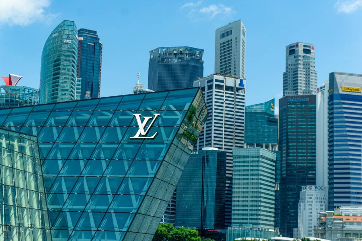 Louis Vuitton building with glass architecture against the backdrop of Singapore's modern skyline on a clear day
