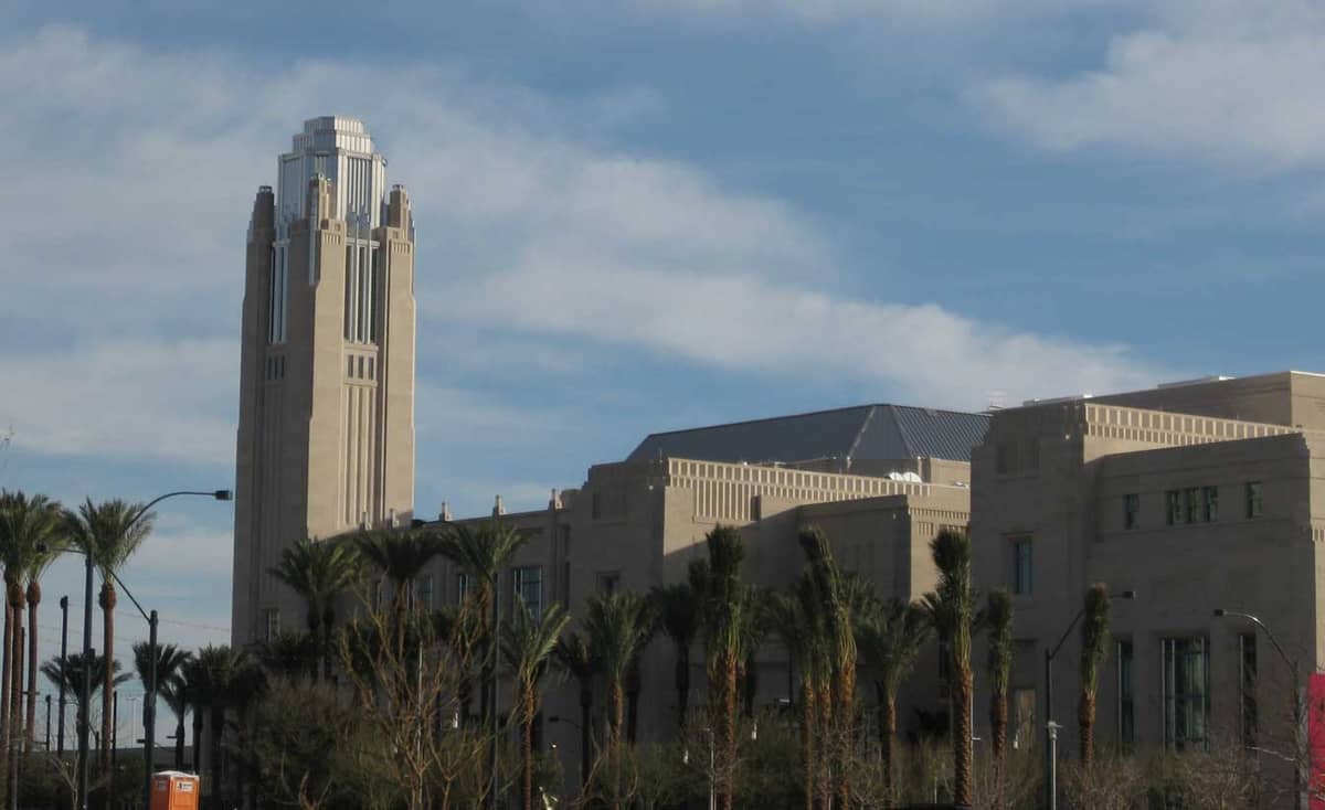 Lo Smith Center for the Performing Arts a Las Vegas, con la caratteristica torre beige in stile Art Deco, le palme e parte della facciata esterna sotto un cielo azzurro.