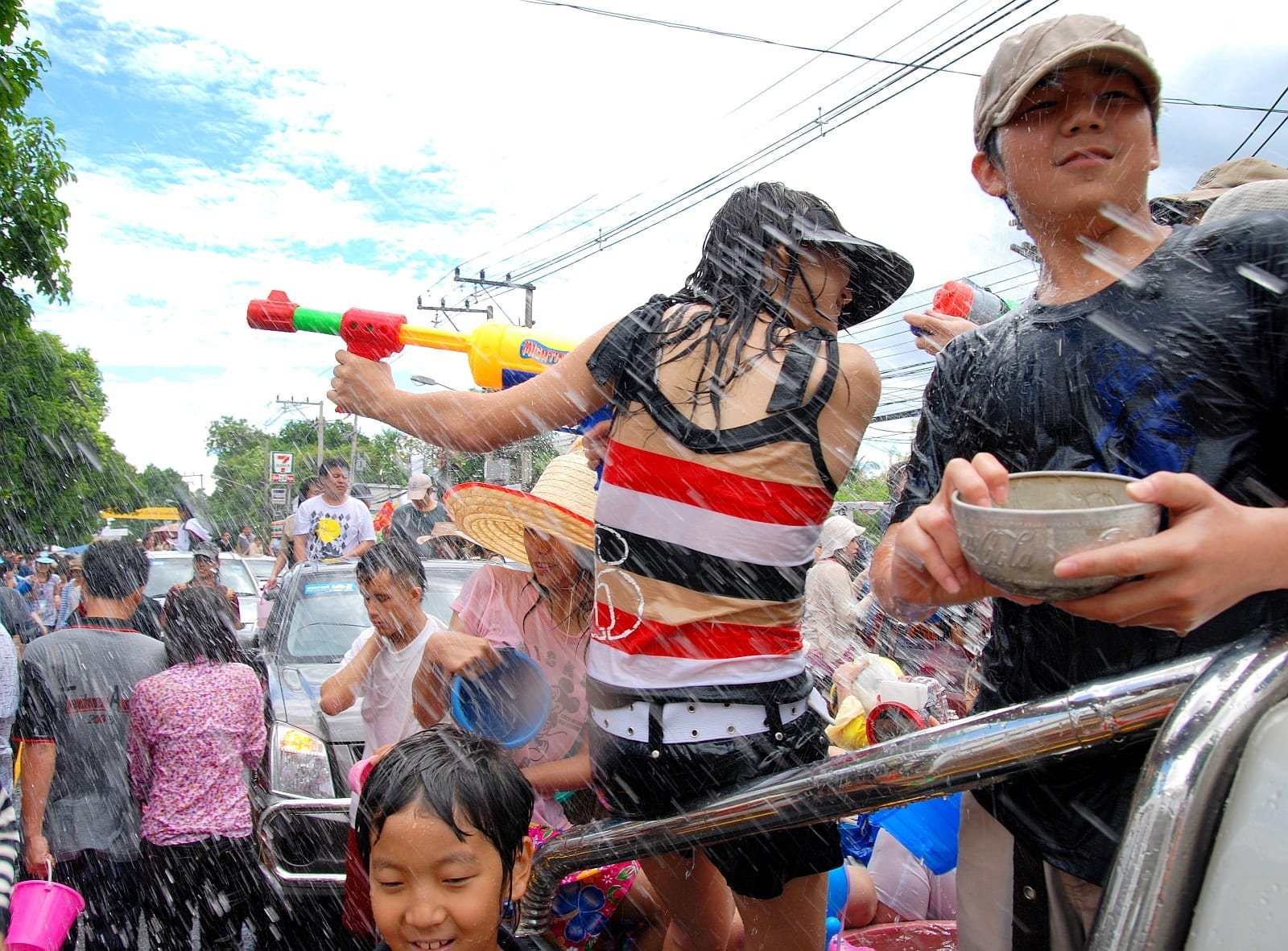 Pessoas celebrando o Songkran em Bangkok com pistolas de água e respingos durante o Ano Novo tailandês
