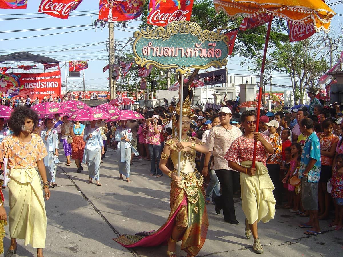 Desfile tradicional de Songkran em Bangkok com pessoas em trajes tailandeses e multidão celebrando o Ano Novo tailandês