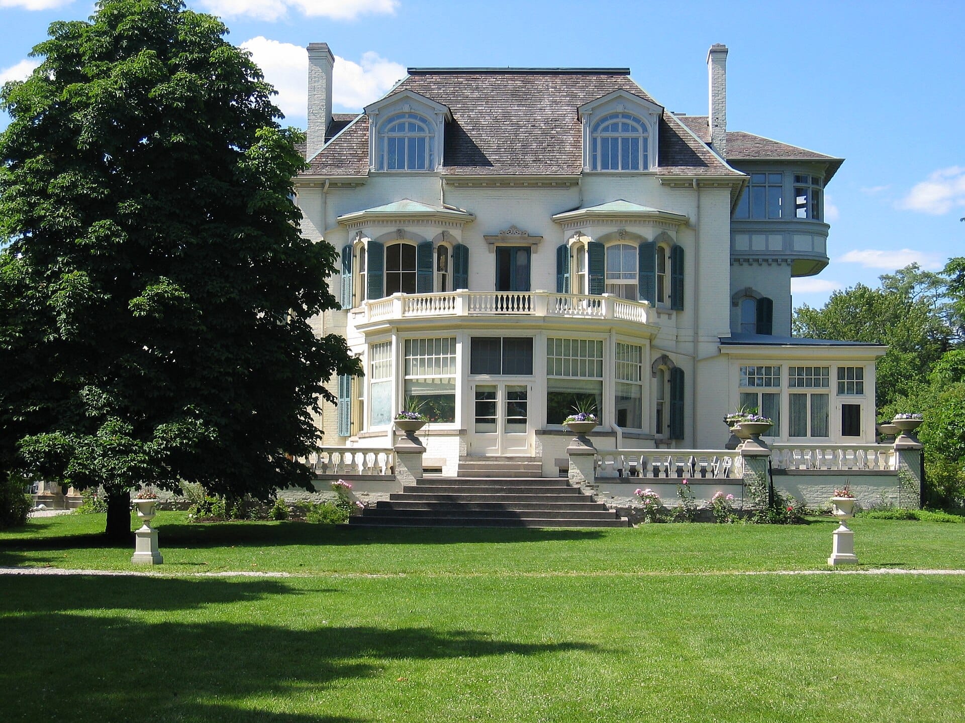 ทัศนียภาพด้านหน้าของ Spadina Museum คฤหาสน์ประวัติศาสตร์อันยิ่งใหญ่พร้อมหน้าต่างแกะสลักและสวนงดงาม ภายใต้ท้องฟ้าสีฟ้าใสในเมือง Toronto