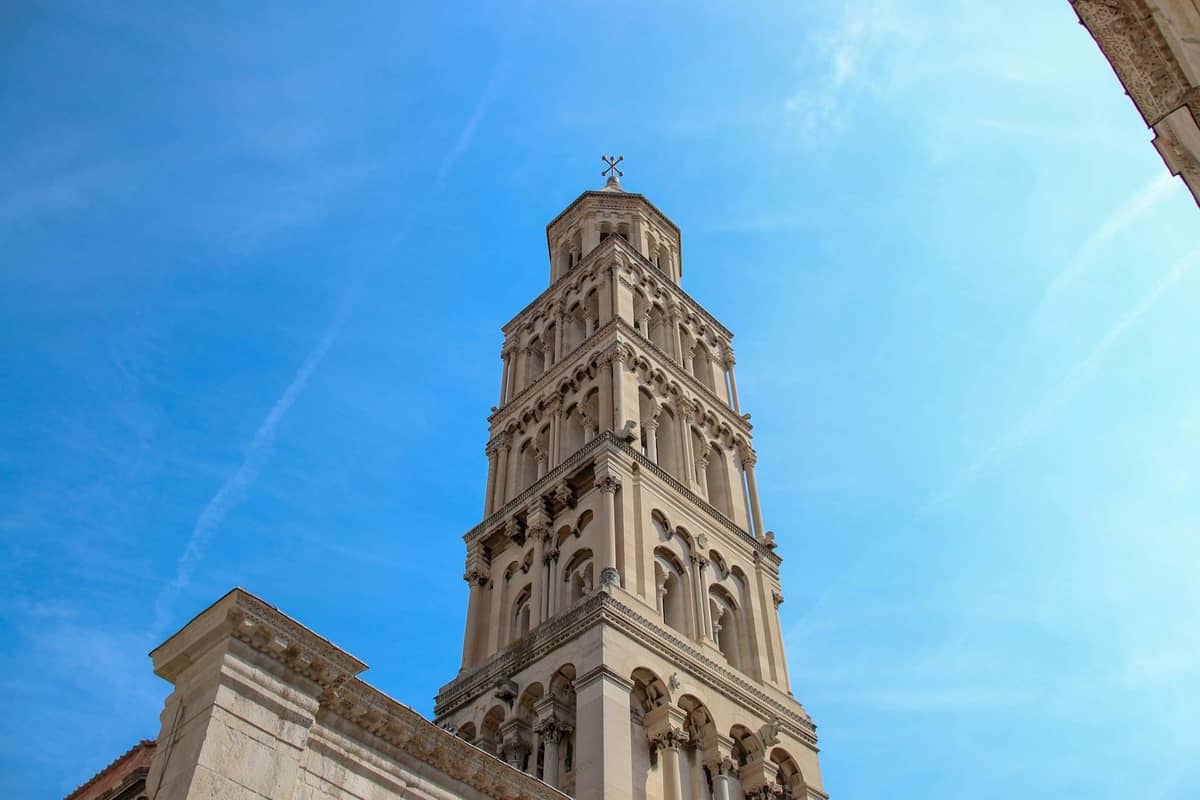 Hoher steinerner Glockenturm der Kathedrale von Split, von unten vor einem strahlend blauen Himmel fotografiert, als herausragende kostenpflichtige Sehenswürdigkeit.