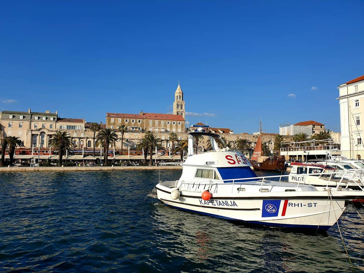 Hafenszene in Split mit einem Polizei- oder Notfallboot, das vor historischen Uferhäusern und dem Kathedralenglockenturm angelegt hat.