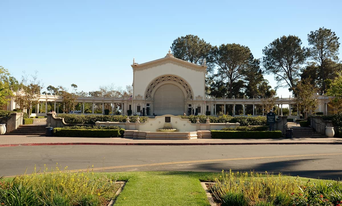 Weitwinkelansicht des Spreckels Organ Pavilion im Balboa Park mit seiner reich verzierten Bogenbühne und der umliegenden Kolonnade an einem klaren Tag.