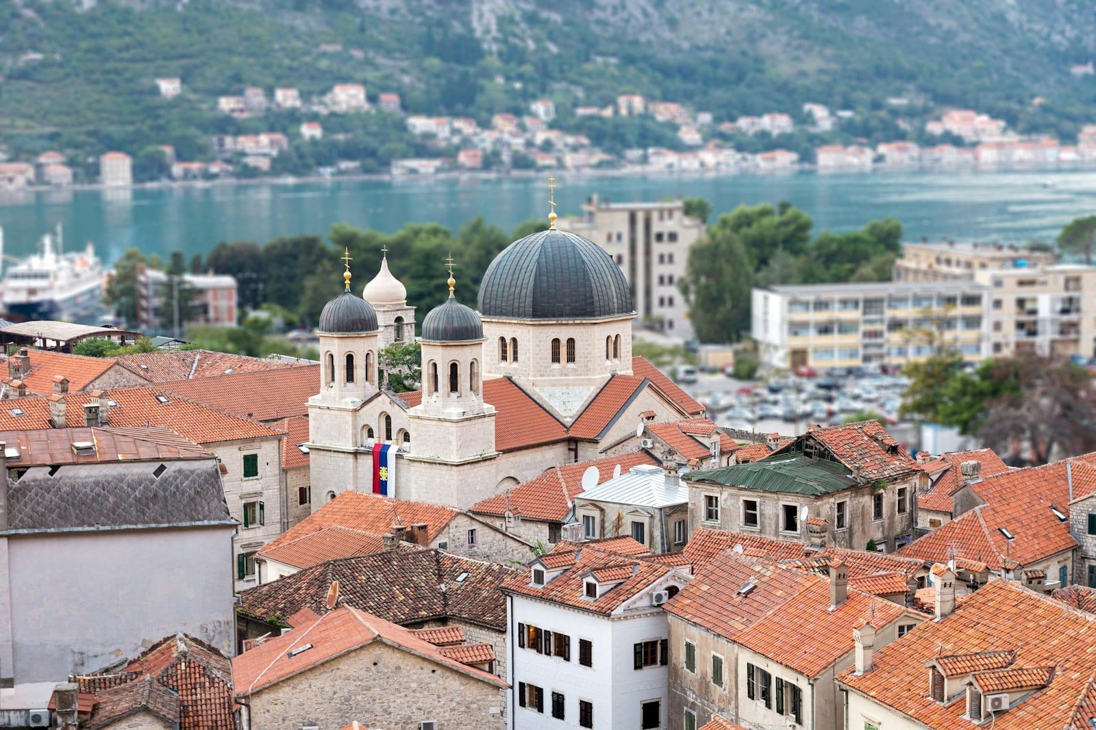 Chiesa di San Nicola nella città vecchia di Kotor con le sue caratteristiche cupole nere e torri gemelle, circondata da tetti di tegole rosse e affacciata sulla baia.