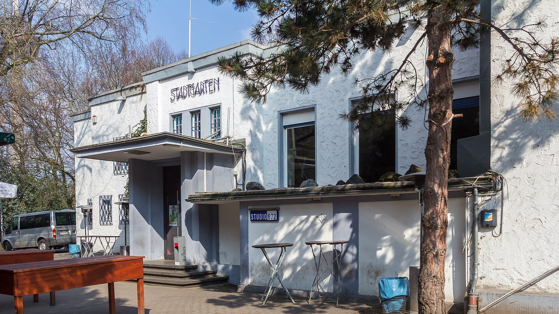 ด้านหน้าอาคาร Stadtgarten ที่โคโลญ เห็นป้ายชื่อและต้นไม้รอบ ๆ ในช่วงกลางวัน