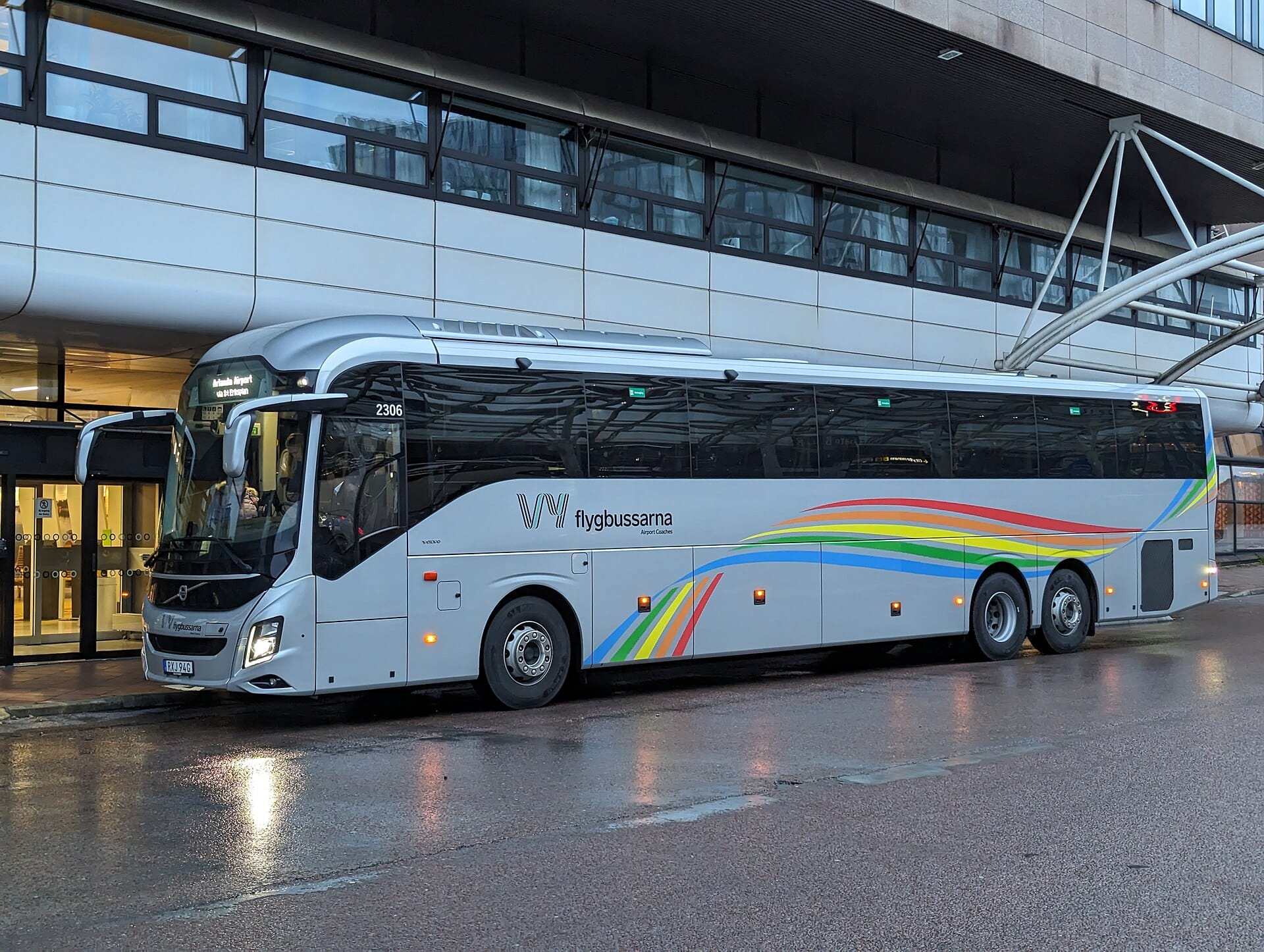 รถโค้ชสนามบิน Flygbussarna จอดอยู่หน้าอาคารผู้โดยสารสนามบิน Stockholm Arlanda ในวันที่มีฝนตก
