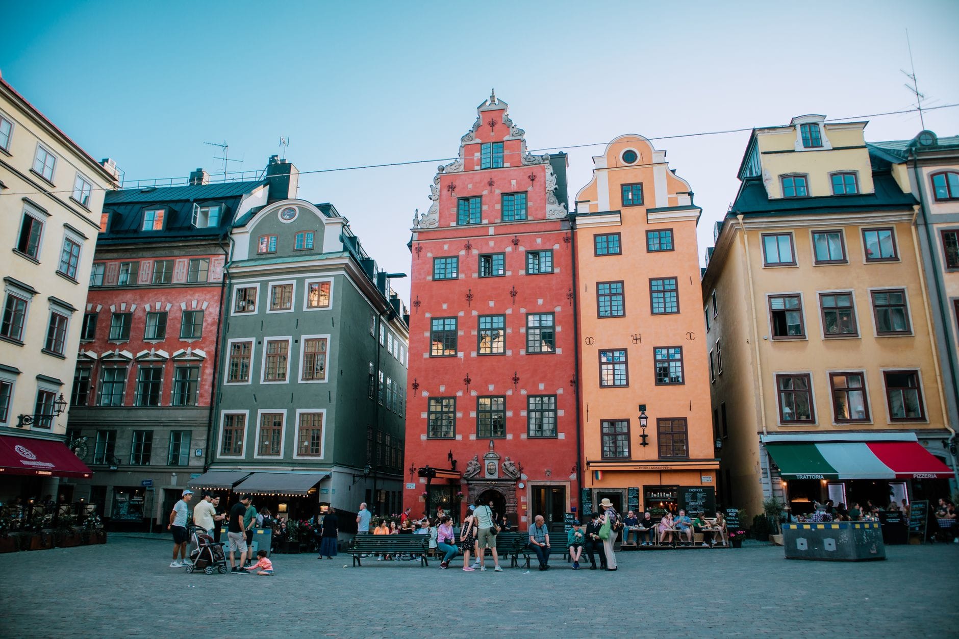 วิวทิวทัศน์ของจัตุรัส Stortorget ใน Gamla Stan เมืองสตอกโฮล์ม พร้อมอาคารหลากสีสันอันเป็นเอกลักษณ์และผู้คนที่มารวมตัวกันกลางแจ้ง