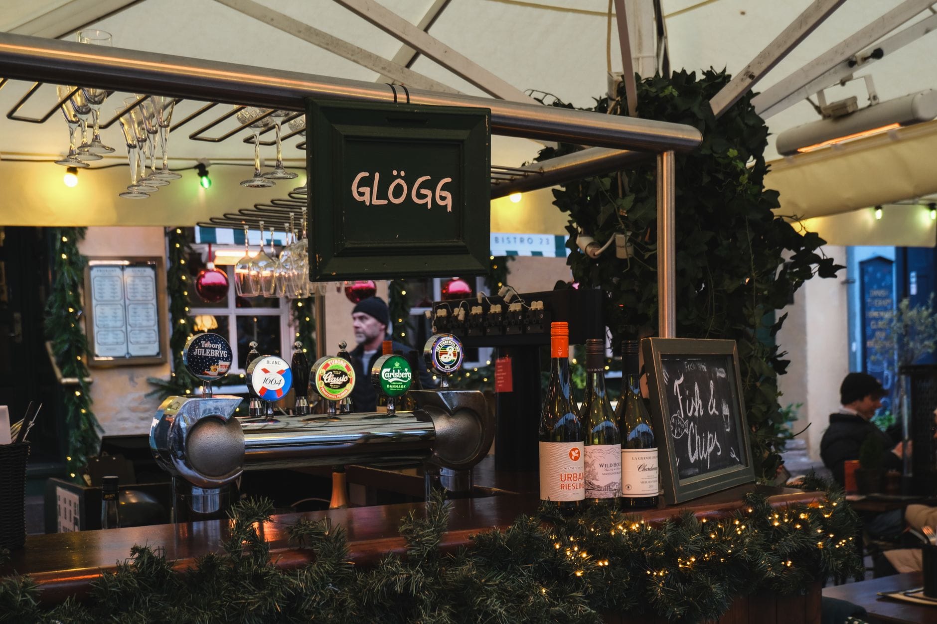 แผงตลาดคริสต์มาสกลางแจ้งในสวีเดนที่จำหน่าย glögg พร้อมขวดและก๊อกน้ำที่ตกแต่งสำหรับเทศกาลวันหยุด