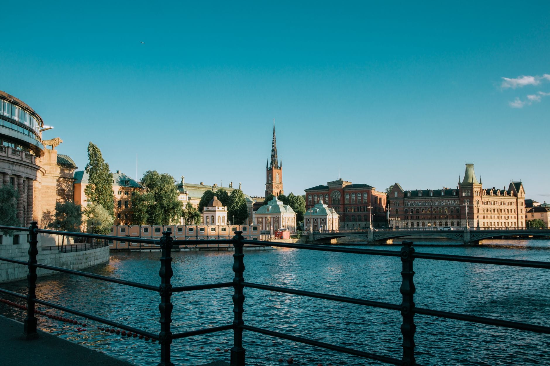 วิวหน้าร้อนคลาสสิกใจกลางสตอกโฮล์ม อาคารเก่าแม่น้ำใส วิวหอคอยโบสถ์ Riddarholmen ท้องฟ้าสีฟ้าสด