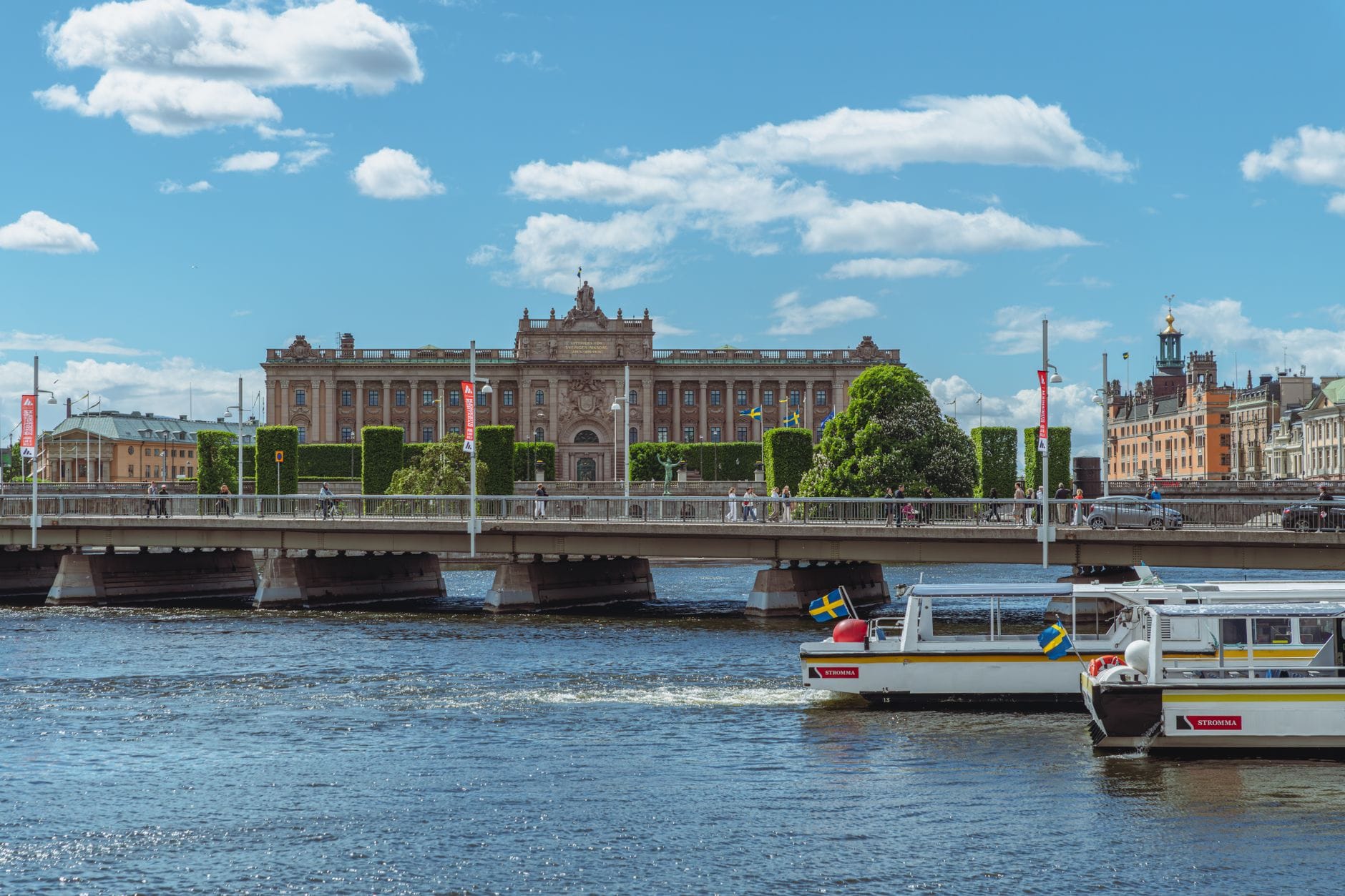 วิวใจกลางเมือง Stockholm พร้อมอาคารรัฐสภา สะพาน และเรือนักท่องเที่ยวบนน้ำด้านหน้า
