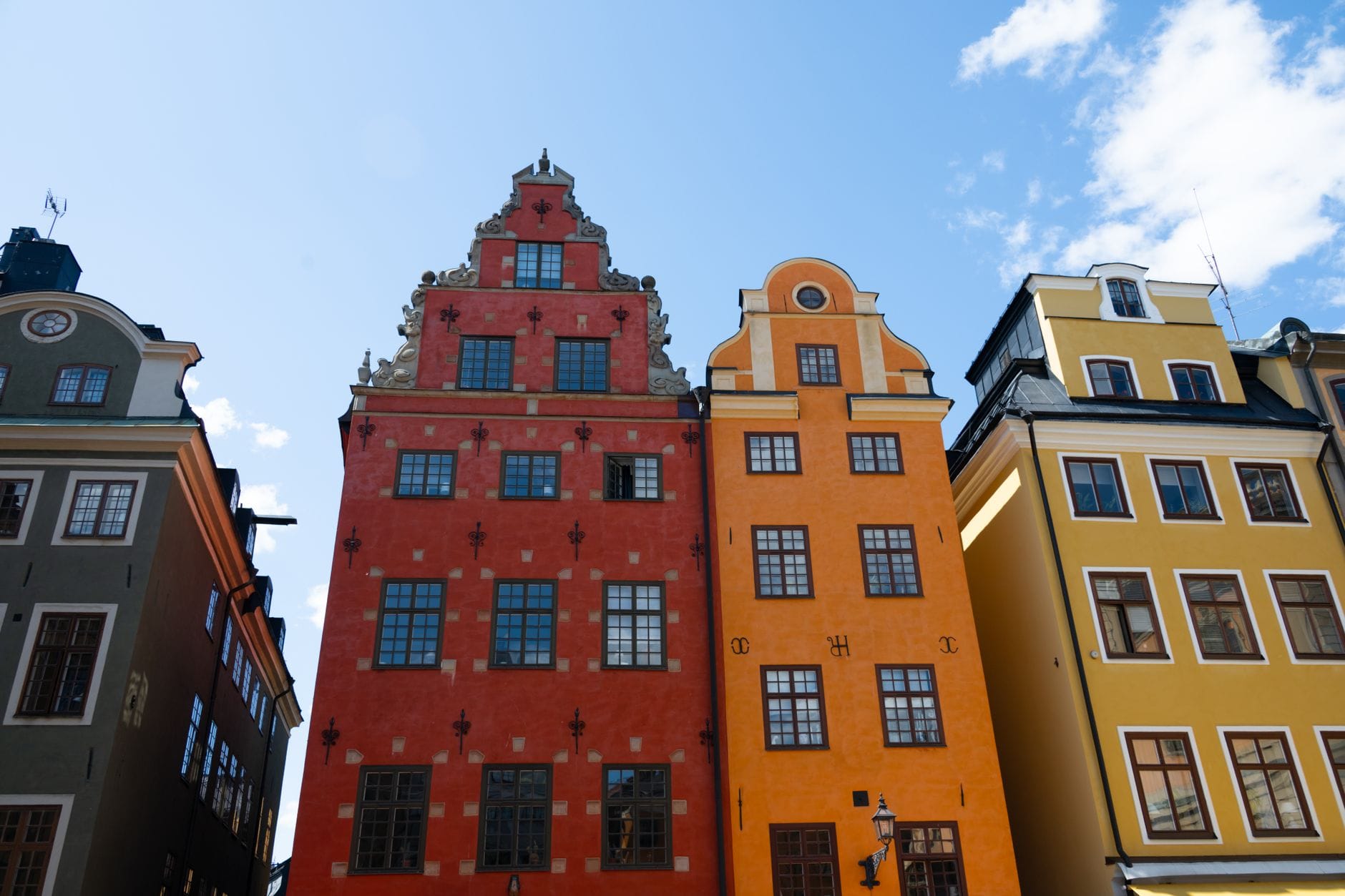 อาคารประวัติศาสตร์หลากสีสันใต้ท้องฟ้าสีฟ้าใน Gamla Stan ใจกลางเมือง Stockholm จุดเริ่มต้นยอดนิยมสำหรับการสำรวจเมือง