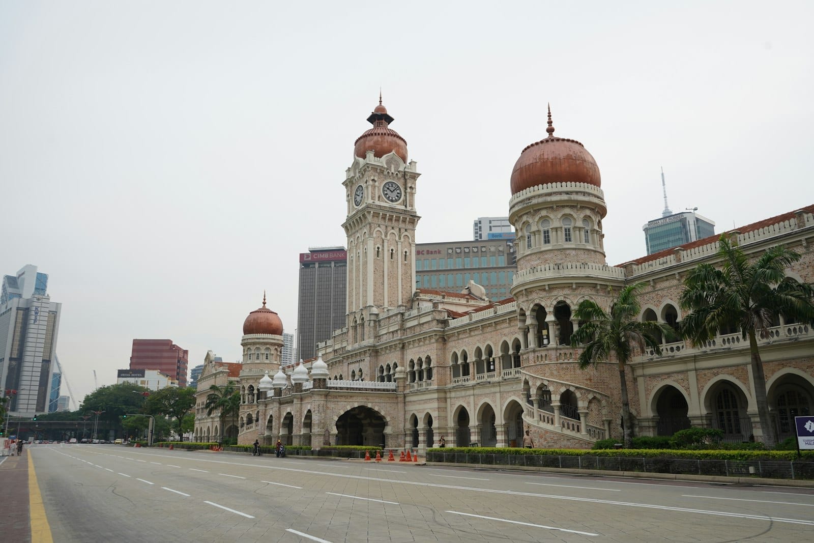 Iconic Sultan Abdul Samad Building with copper-green domes and Moorish arches rising over Merdeka Square in Kuala Lumpur.