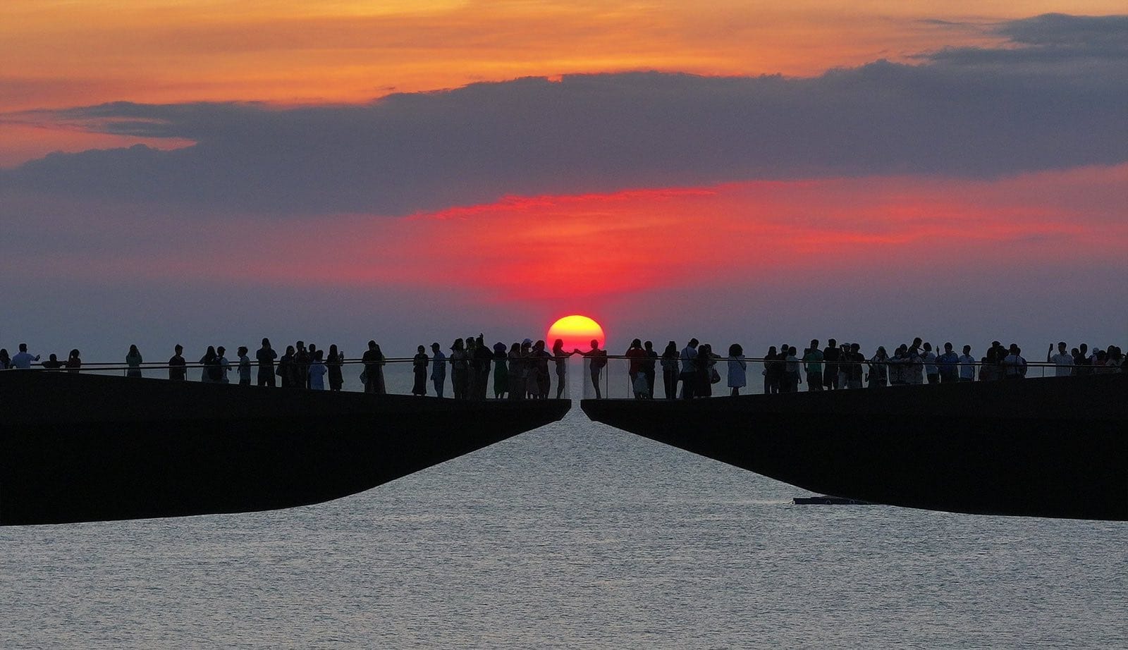 Kiss Bridge (Cầu Hôn) a Sunset Town Phu Quoc con la folla che osserva il tramonto sul mare tra le due piattaforme