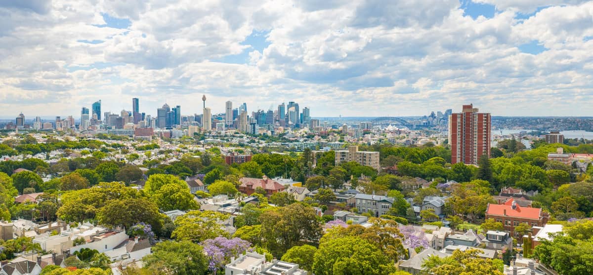 ภาพมุมสูงของ Surry Hills และ Darlinghurst ถนนเงียบร่มรื่น บ้านระเบียงพักอาศัย และฉากหลังเป็น CBD ของซิดนีย์ใต้ท้องฟ้ามีเมฆบาง ๆ