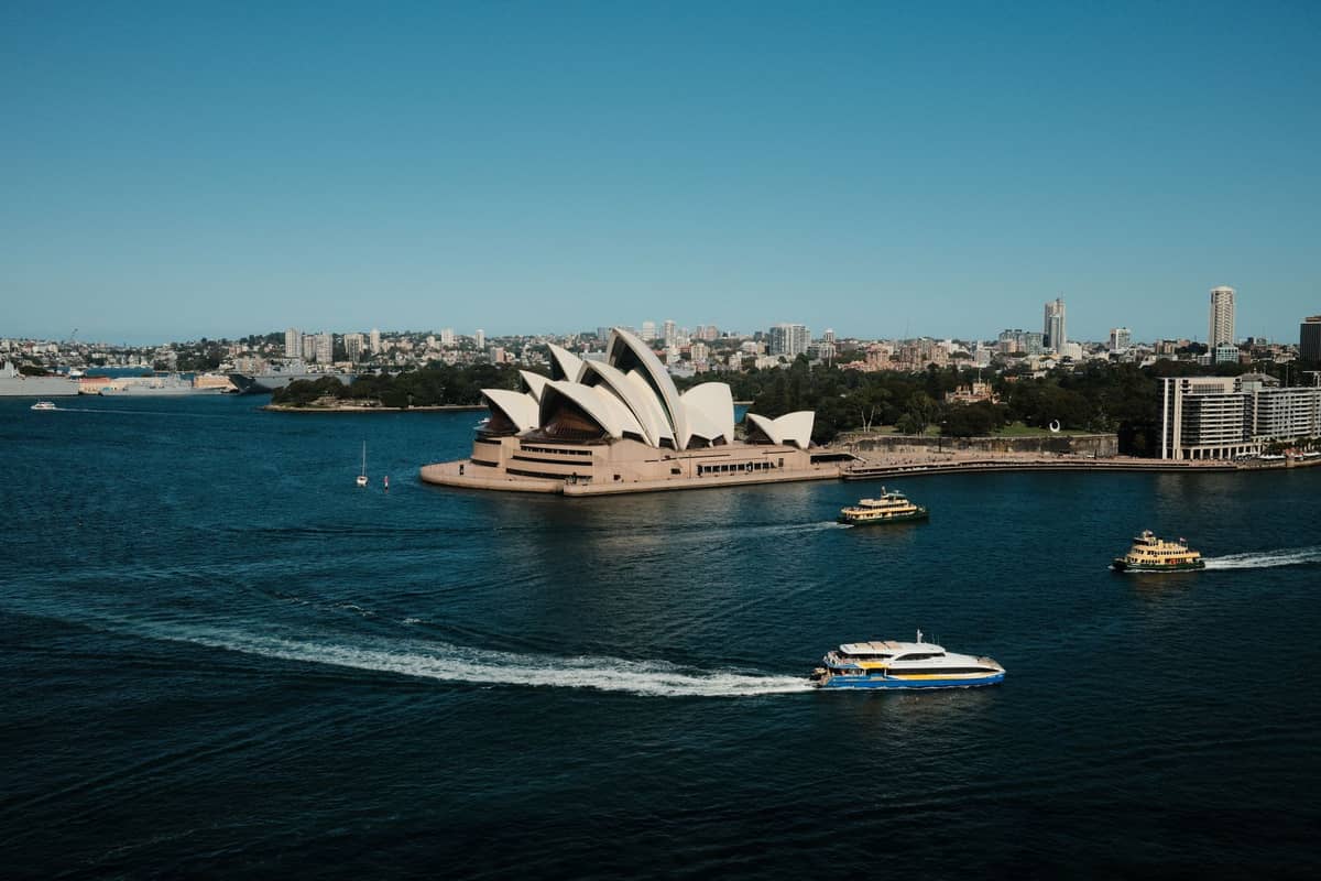 Panoramiczny widok na Sydney Harbour z promami przepływającymi przed Operą w Sydney, ilustrujący aktywną sieć promową i malownicze trasy.