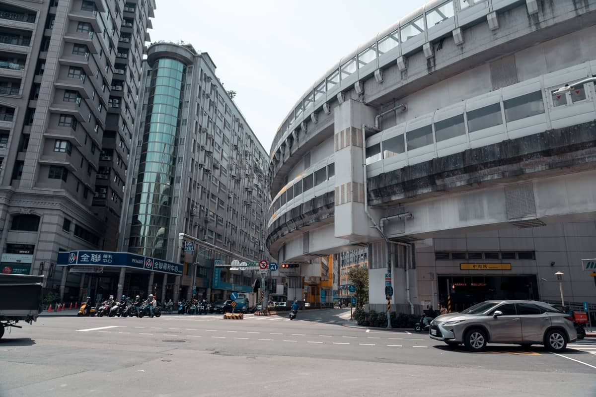 Moderne Stadtstraße in Taipei mit Hochhäusern, sichtbarer U-Bahn-Infrastruktur und klaren urbanen Internetinfrastrukturelementen.
