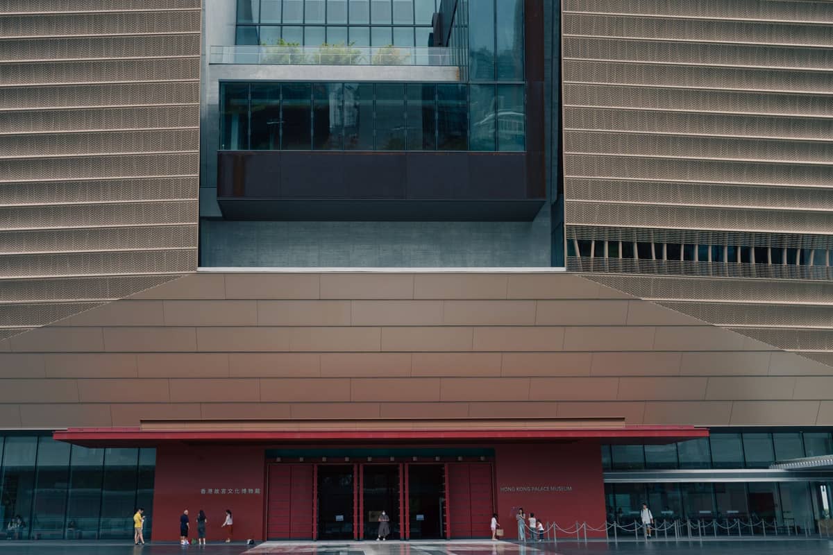 Modernes Außengebäude des Taipei Fine Arts Museum mit Menschen, die davor spazieren gehen, und der markanten Architektur des Gebäudes.