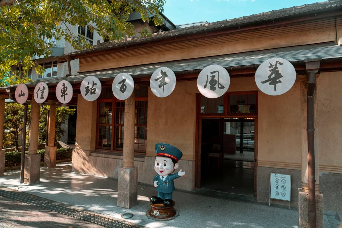 Traditionelles Gebäude mit runden chinesischen Schildern und einer Cartoon-Polizeistatue vor dem Eingang, wahrscheinlich ein einzigartiges Spezialmuseum in Taipei.