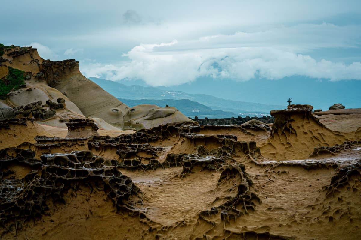 Verwitterte Sandsteinfelsenformationen unter einem bewölkten Himmel im Yehliu Geopark an der Nordküste Taiwans.