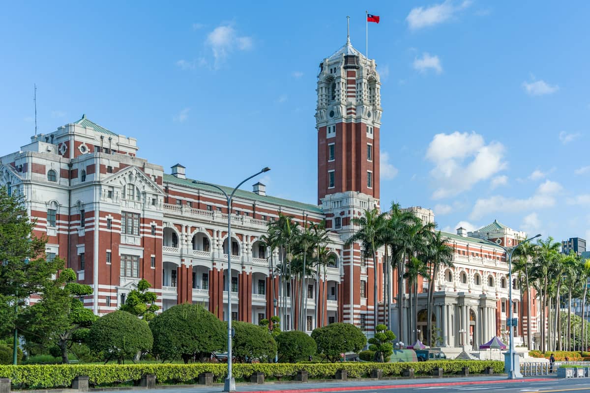 Weitwinkelansicht des historischen rot-weißen Präsidentschaftsbürogebäudes von Taipei, einem ikonischen Bauwerk im japanisch-kolonialen Barockstil im Zhongzheng-Bezirk unter blauem Himmel.
