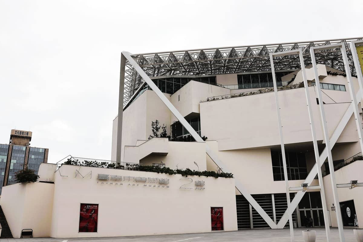 Modernes weißes Äußeres des Taipei Performing Arts Center mit markanter geometrischer Gestaltung und sichtbarer Beschilderung am Gebäude.