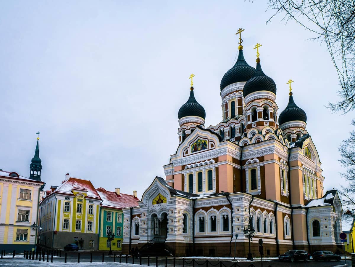 Die Alexander-Newski-Kathedrale steht auf dem Toompea-Hügel in Tallinn, umgeben von bunten historischen Gebäuden unter einem bedeckten Winterhimmel.